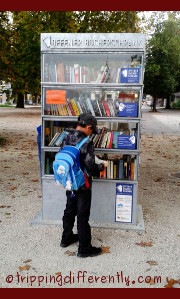 The bookcase is made of metal and has glass panels to protect the books.